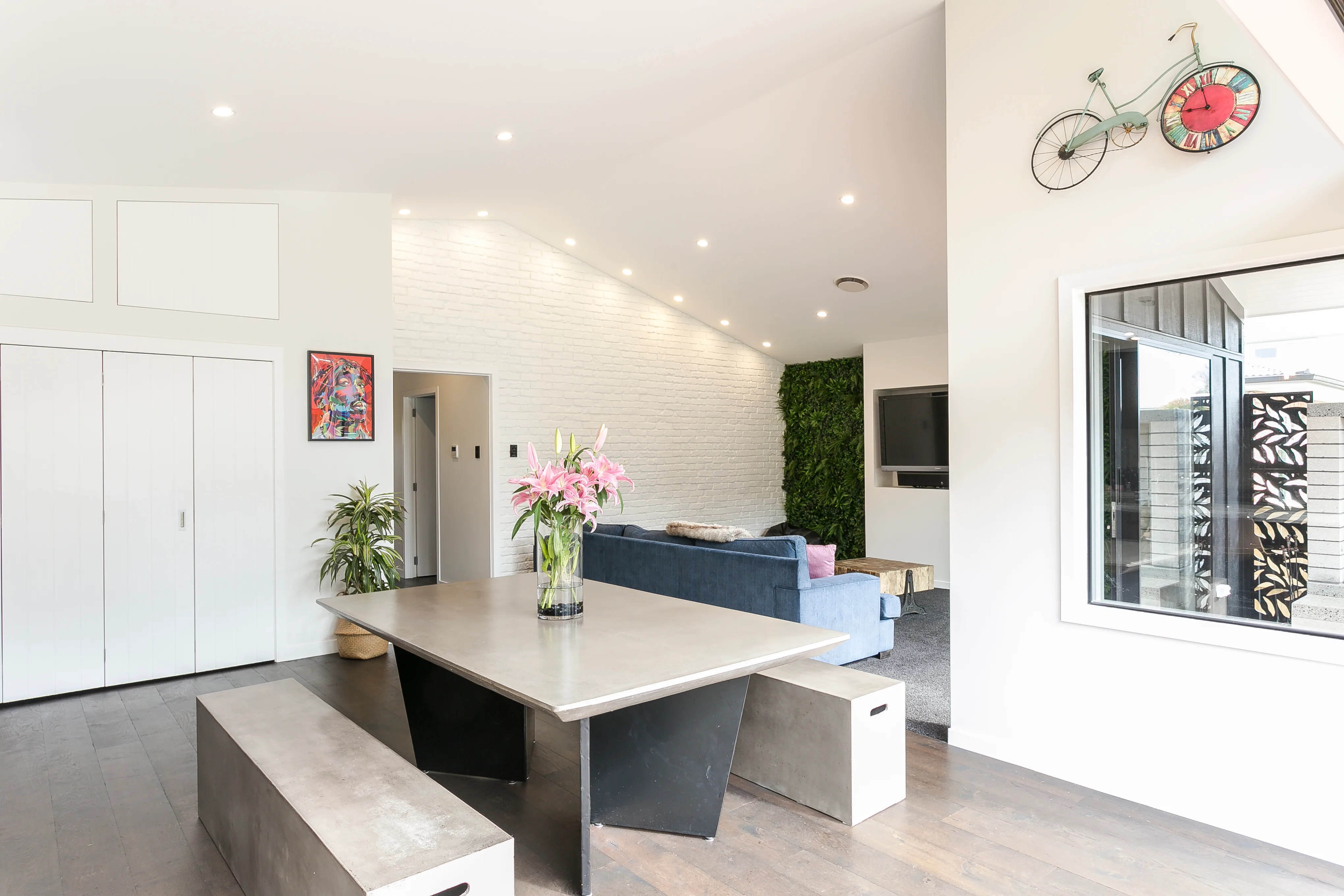 Hazelmere house – living area with white brick feature wall and dining table