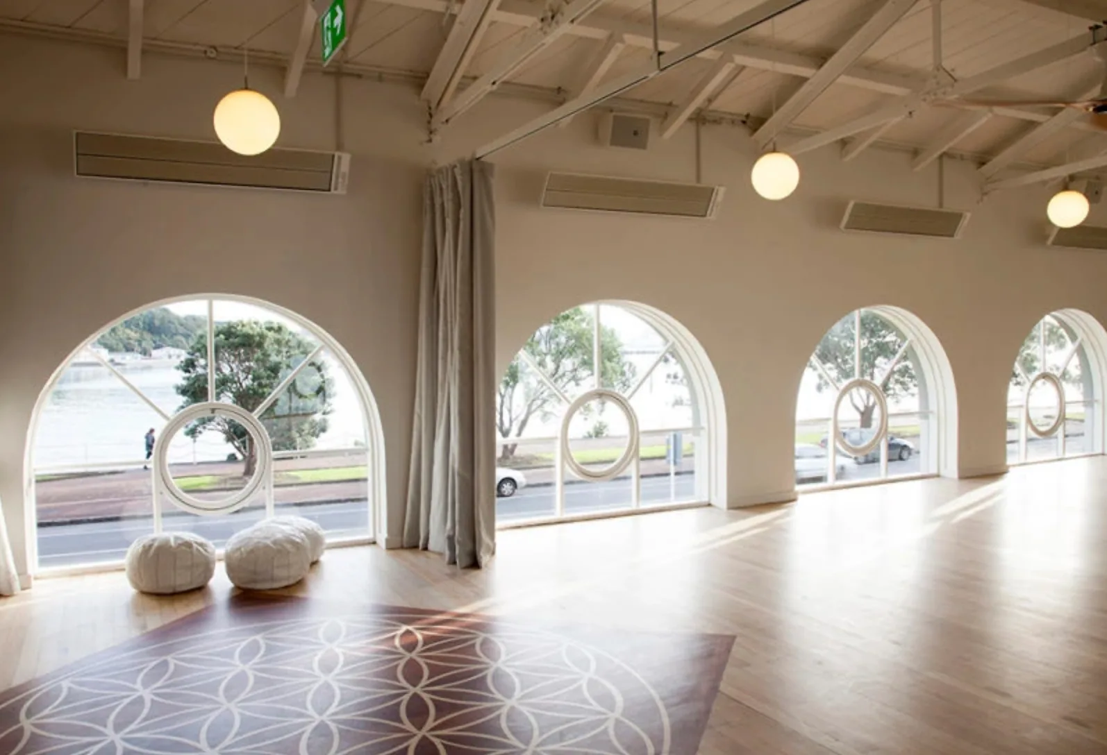 True Food and Yoga – yoga studio with vaulted ceiling, arched windows and floor cushions overlooking the harbour