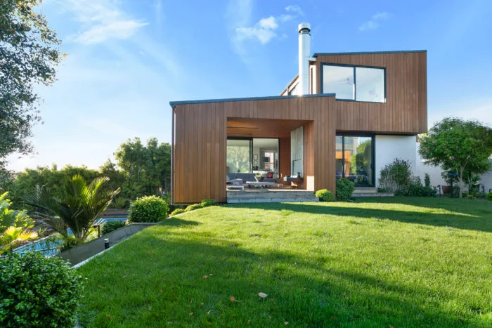 Calder – cedar-clad rear exterior with covered outdoor room, lawn and pool