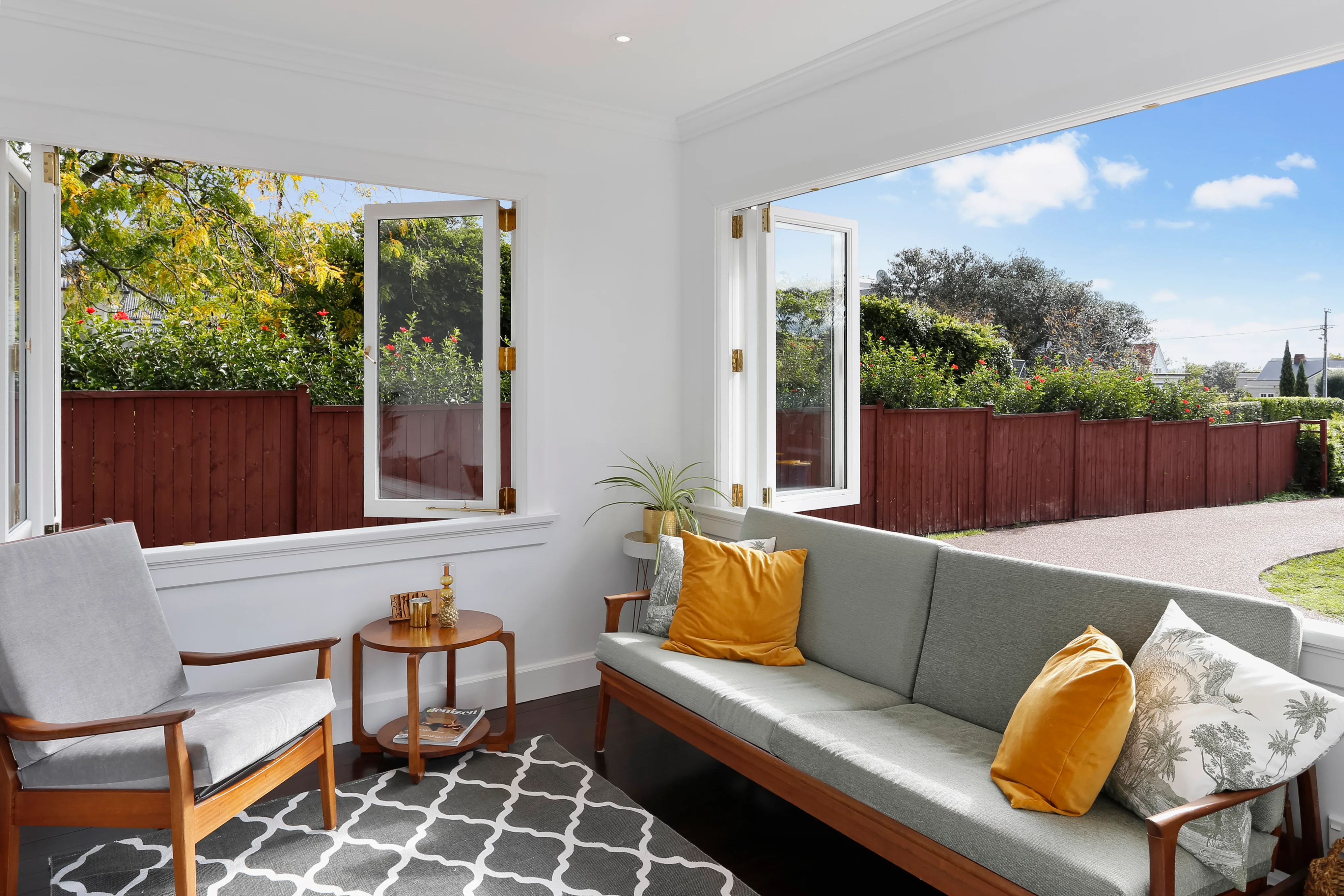 Stanley Point – sunroom with armchair, sofa and folding windows onto the garden