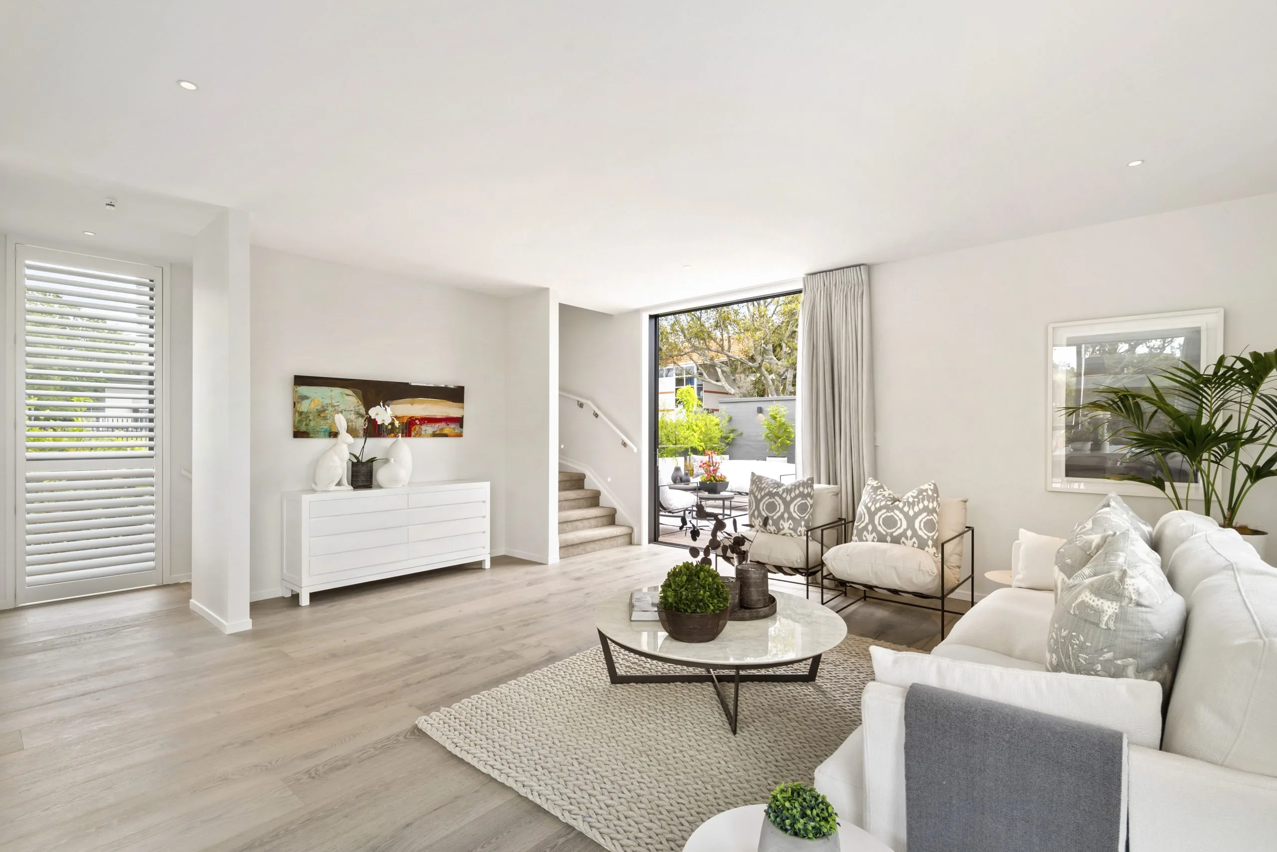 Curran – living room with staircase to the rooftop deck, sideboard and artwork