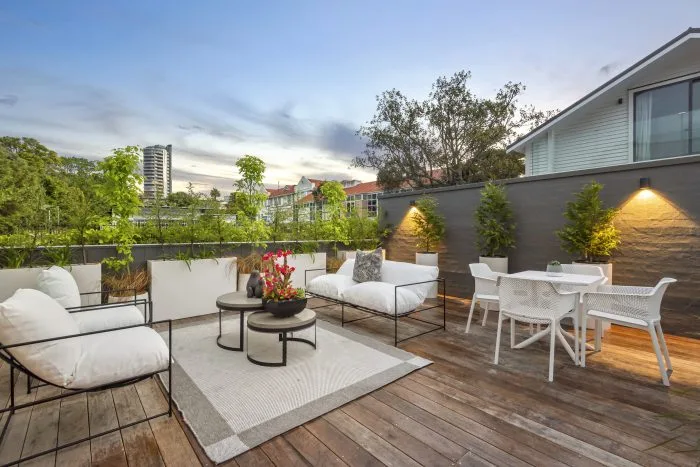 Curran – rooftop deck at dusk with lounge seating and up-lit planter boxes