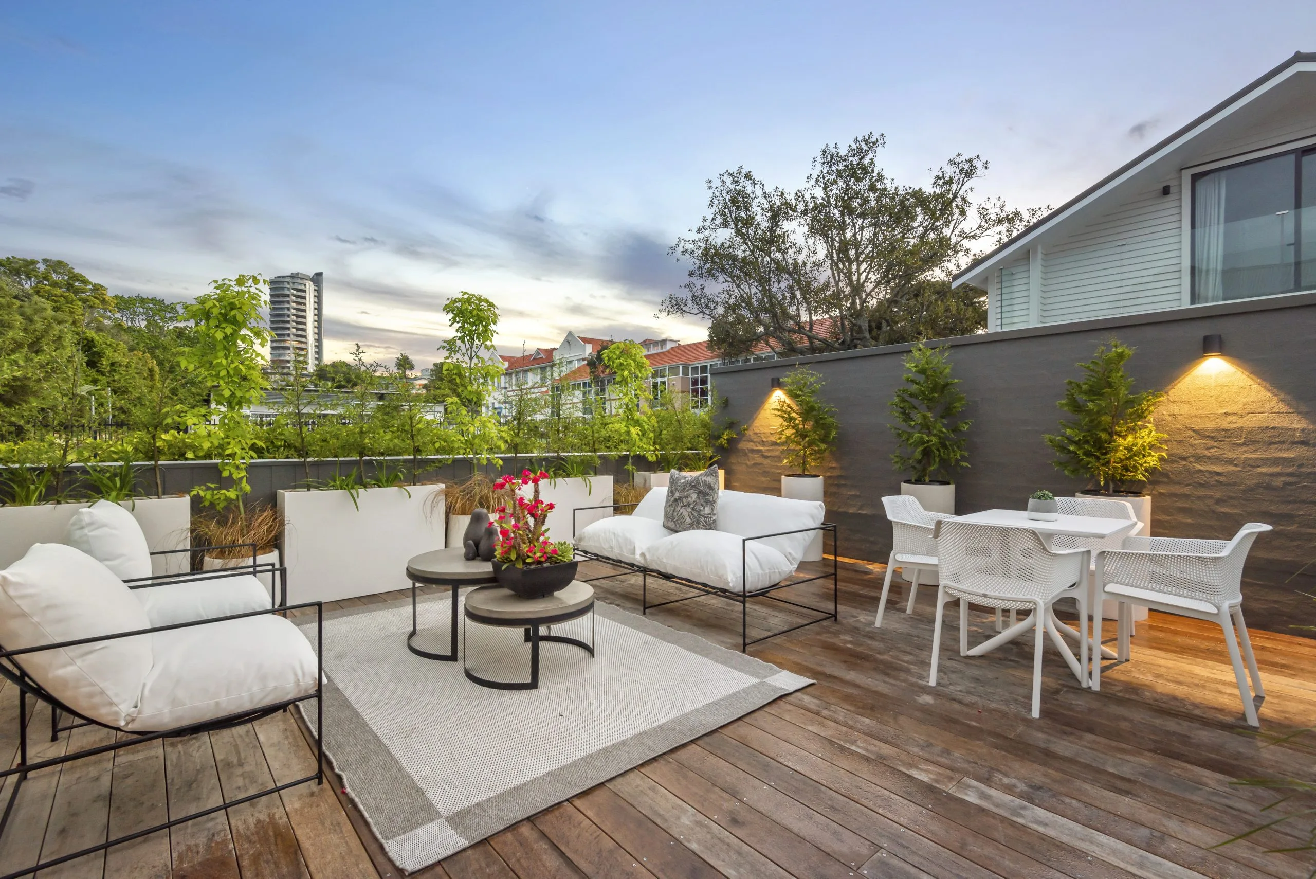 Curran – rooftop deck at dusk with lounge seating and up-lit planter boxes