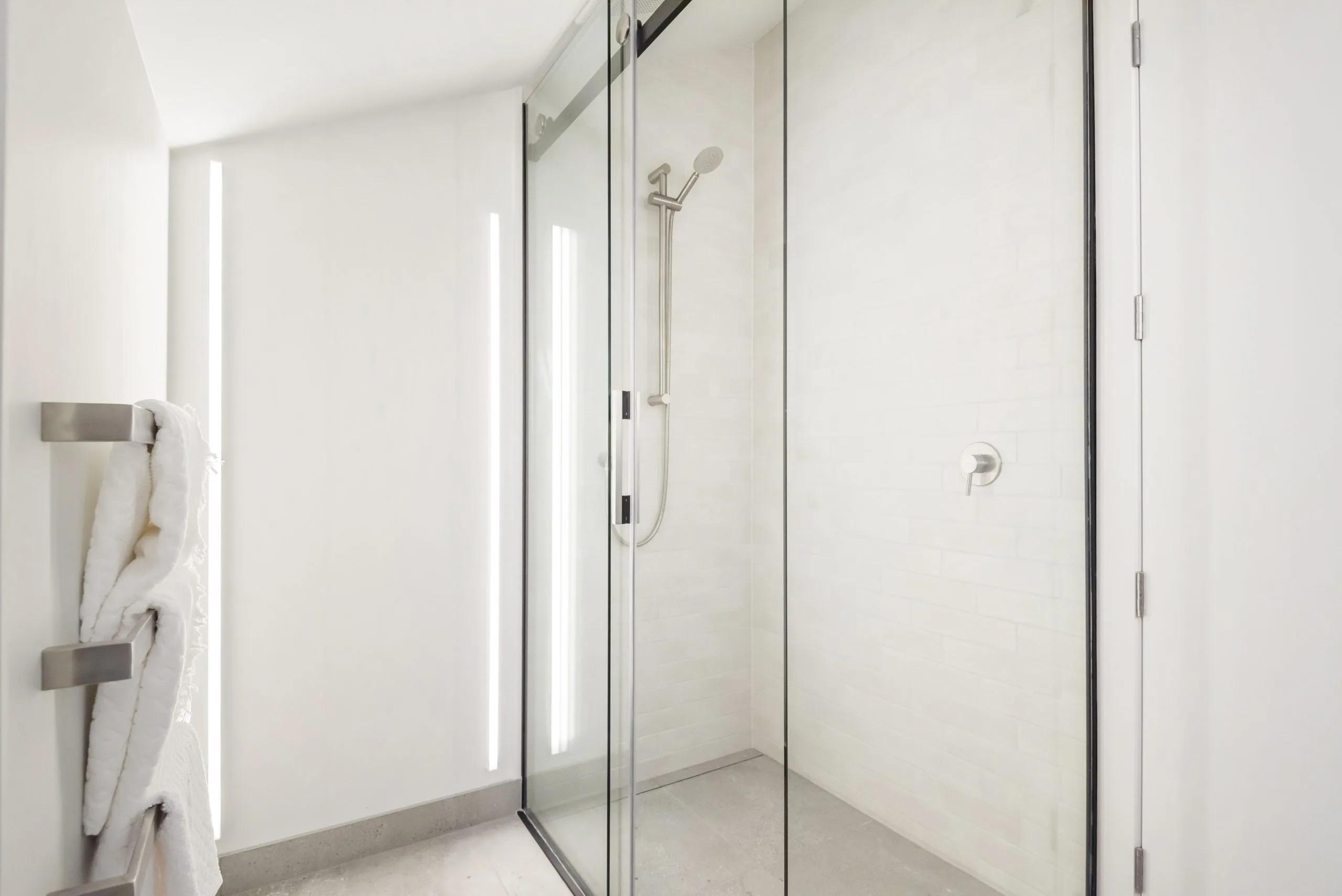 Curran – walk-in glass shower with tiled walls and a wall-mounted towel rail