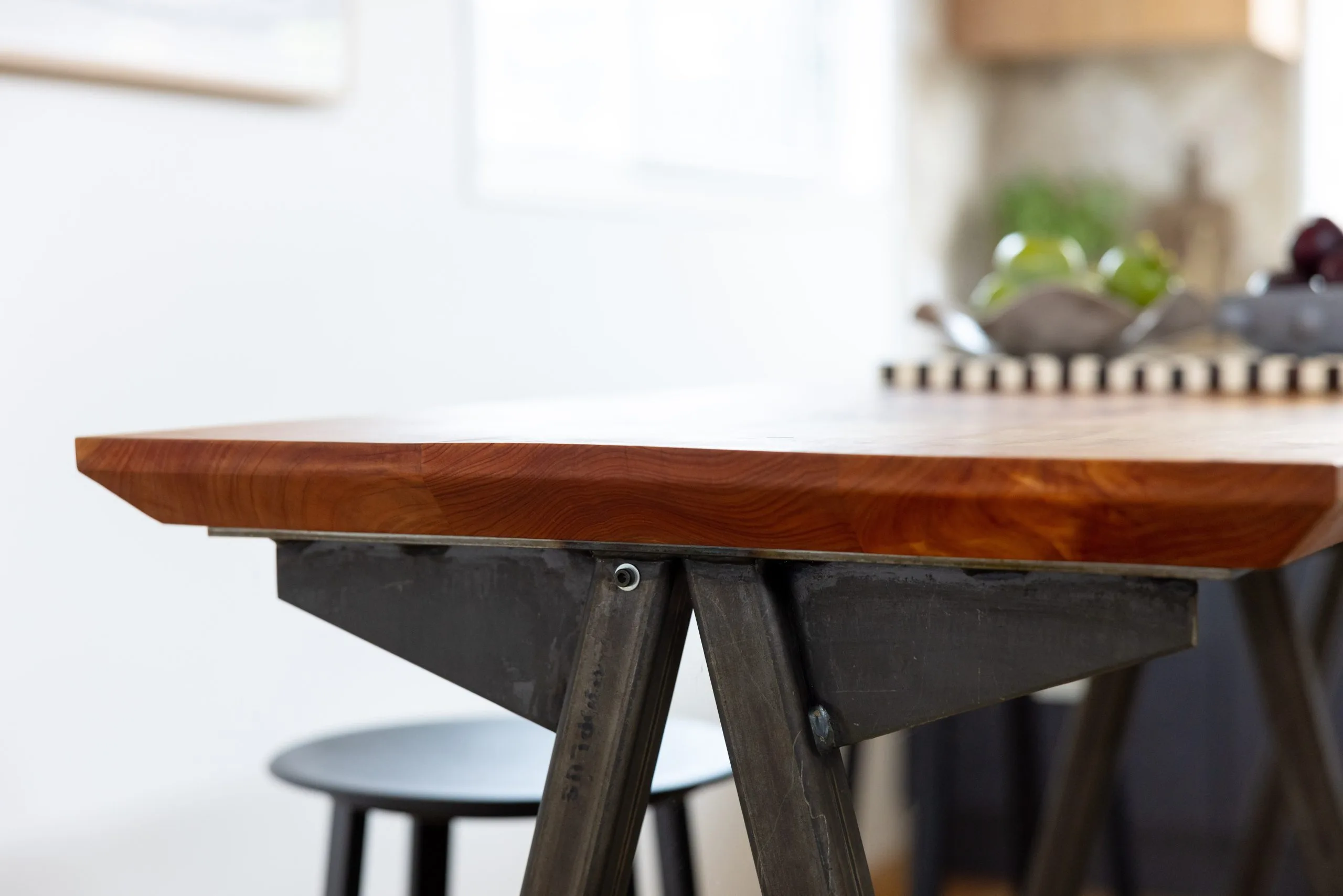 Deep Creek – detail of the timber dining table's edge and steel trestle base