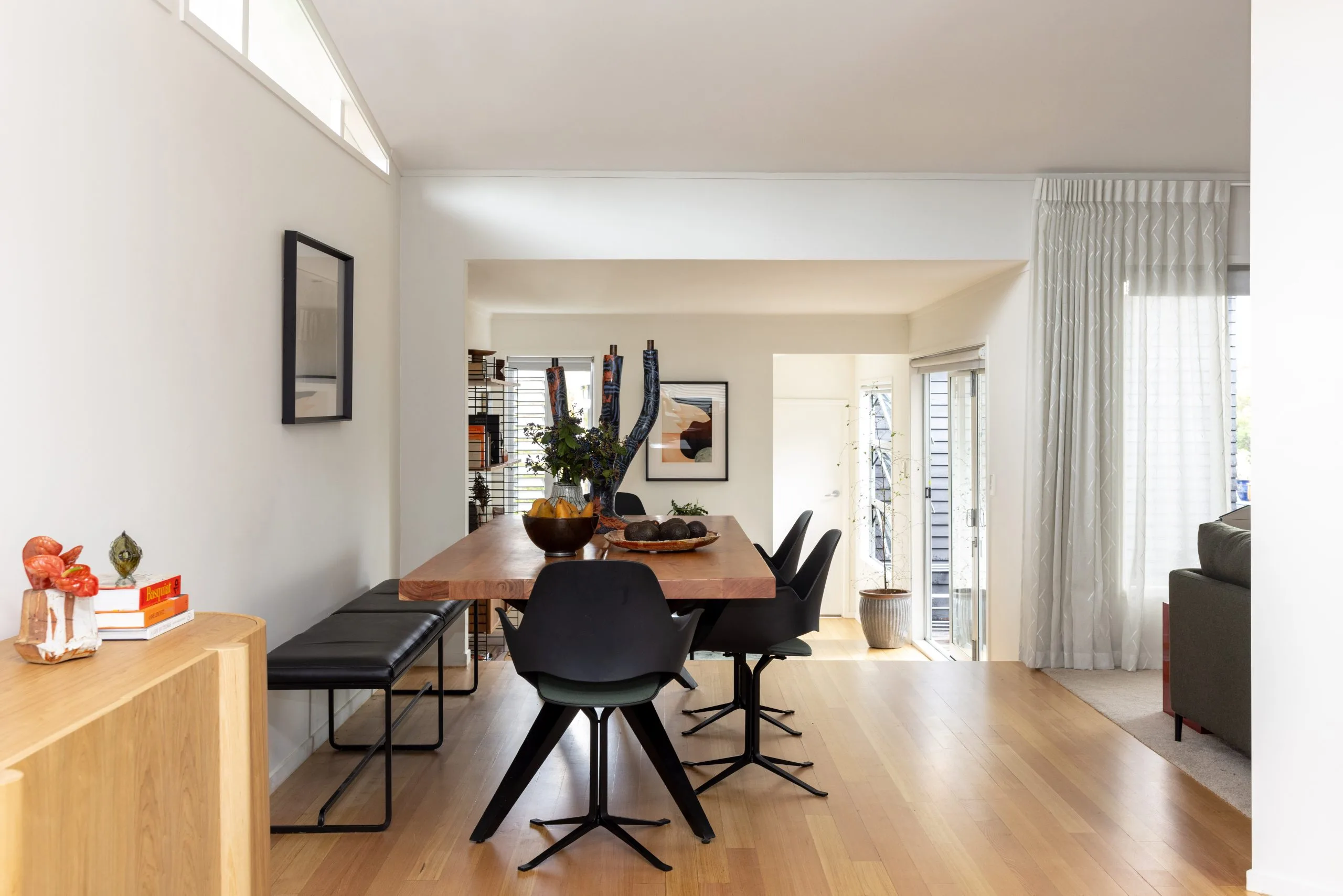 Deep Creek – dining table looking through to the living area, bookshelves and rear door beyond