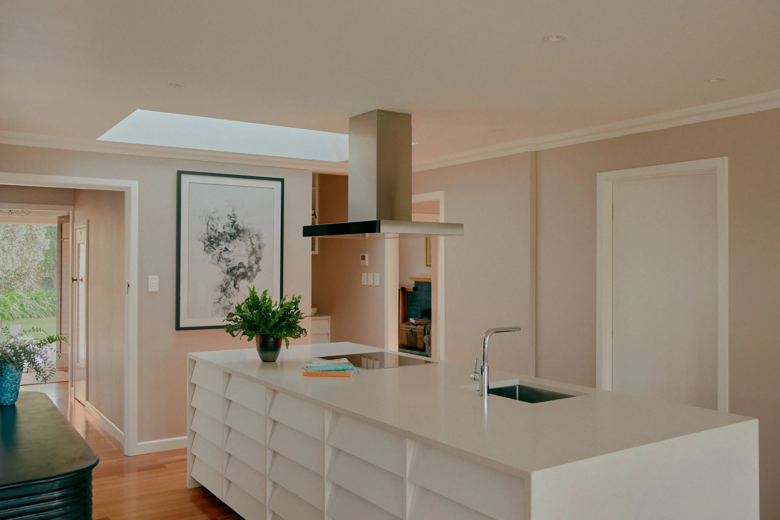 Kitenui Kitchen – white island with induction cooktop opening to the living area