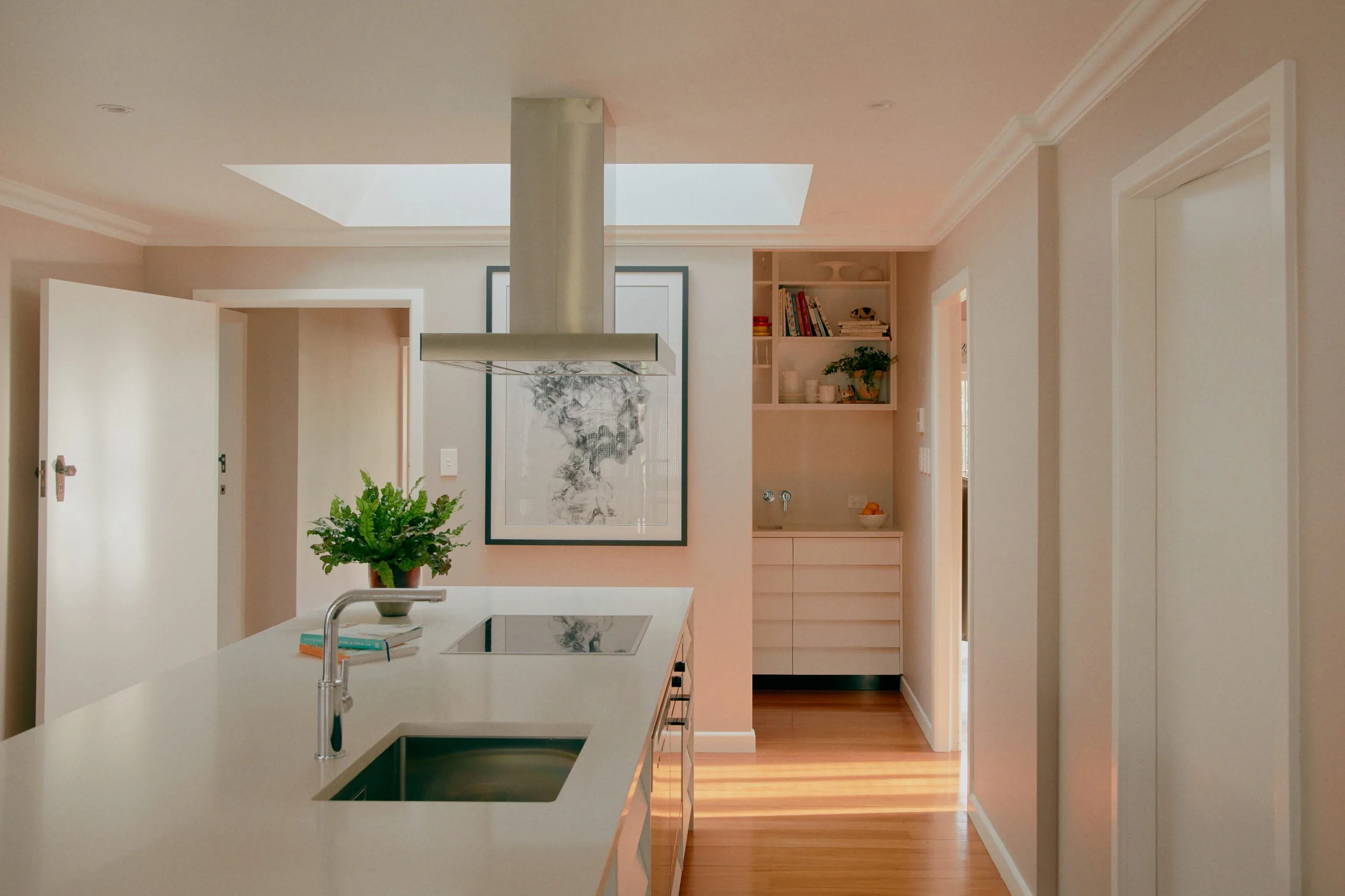 Kitenui Kitchen – white island with induction cooktop opening to the living area