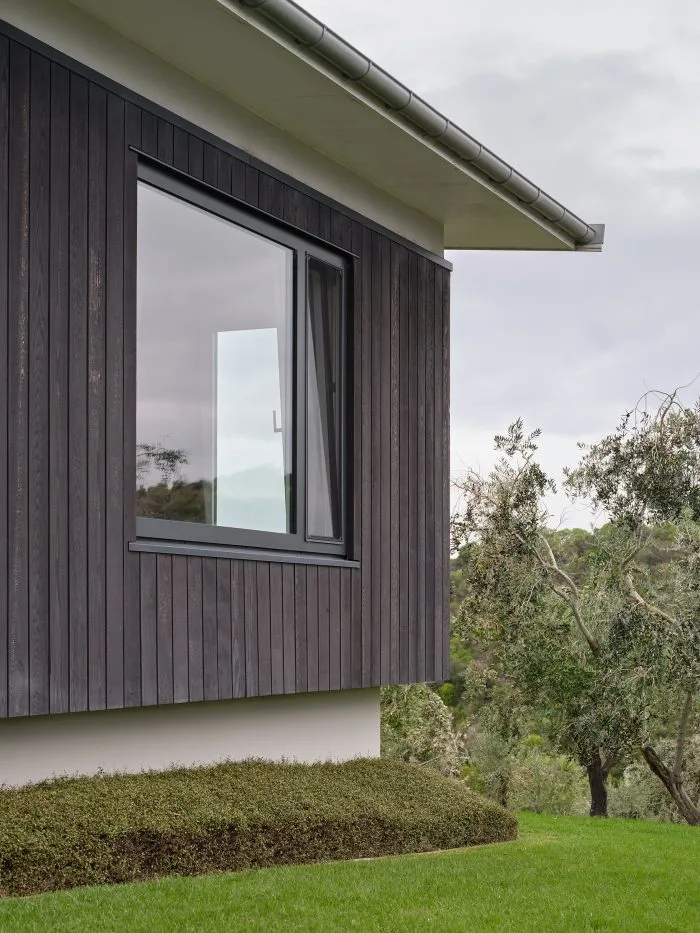 Waiheke Grove House – detail of the dark stained cedar cladding and corner window